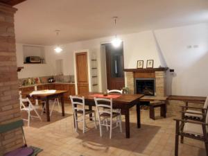 Agriturismo Fonte Carra في Grottazzolina: مطبخ وغرفة طعام مع طاولة ومدفأة