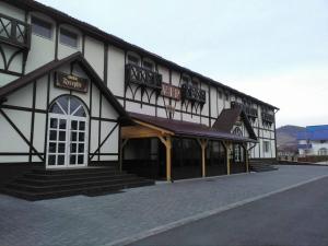 ein großes Gebäude mit einem großen Fenster und einer Veranda in der Unterkunft Vip Motel Restaurant in Haţeg