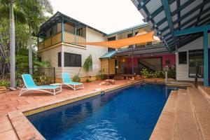 a swimming pool with two chairs and a house at The Courthouse Bed & Breakfast in Broome