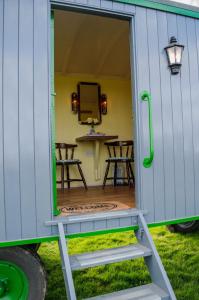 uma porta para uma pequena casa com um pátio em Shrublands Farm Shepherd's Hut em Sidestrand