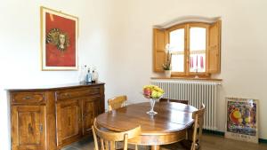 a dining room table with a vase of flowers on it at Casa Ollie in Castel San Gimignano