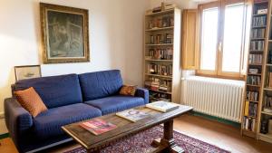 a living room with a blue couch and a table at Casa Ollie in Castel San Gimignano