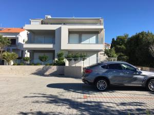 a silver car parked in front of a house at Apartments Lana in Novalja