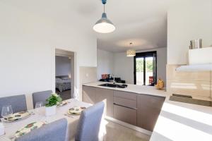 a kitchen and dining room with a table and chairs at Apartments Ester Victoria in Medulin