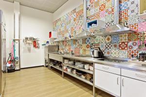 a kitchen with colorful tiles on the wall at Hostelle - female only hostel Amsterdam in Amsterdam