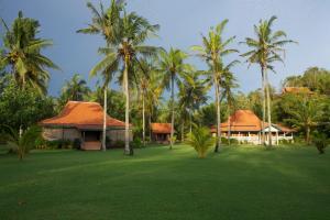 a resort with palm trees and a green lawn at Desa Limasan Resort in Kalak