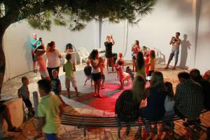 a group of people watching people performing on a stage at Blumarine Residence Club in Ostuni +74 photos