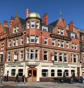 un gran edificio de ladrillo rojo en una calle de la ciudad en Bentinck Hotel en Nottingham