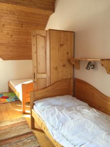 a bedroom with a bed in a room with wooden walls at Tatralandia Romantická Záhrada Chata 345 in Vyšné Malatíny