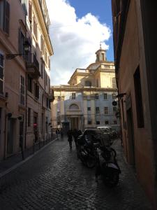 uma rua de calçada com um edifício com uma torre de relógio em Pantheon Old Suite em Roma