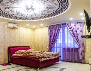 a bedroom with a bed and a ceiling with purple curtains at New VIP Verona APARTMENT 2019 Very Center in Kherson