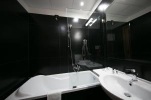 ein Badezimmer mit einem weißen Waschbecken und einem Spiegel in der Unterkunft Mediterranea Hotel & Convention Center in Salerno