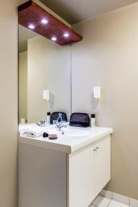 a bathroom with a sink and a mirror at Aparthotel Adagio Access Paris Vanves - Porte de Châtillon in Vanves