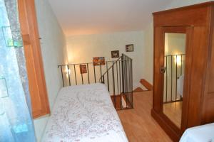 Habitación pequeña con cama y escalera en casetta za' Lucia en Rocca San Giovanni