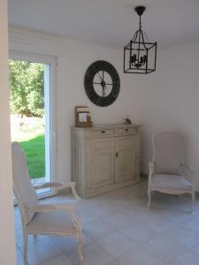 a room with two chairs and a clock on the wall at Fairbanks in Hardecourt-aux-Bois