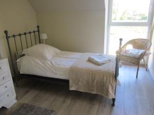 sypialnia z łóżkiem, krzesłem i oknem w obiekcie Fairbanks w mieście Hardecourt-aux-Bois