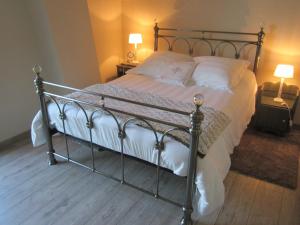 a bedroom with a large bed with white sheets at Fairbanks in Hardecourt-aux-Bois