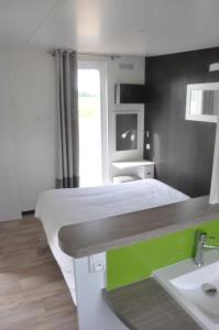 ein Schlafzimmer mit einem Bett mit einem Waschbecken und einem Spiegel in der Unterkunft Les Cottages des Pierres d'Aurèle in Saint-Georges-sur-Cher