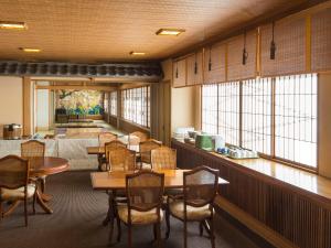 洞爺湖的住宿－洞爺歌吉拉庫日式旅館，用餐室设有桌椅和窗户。