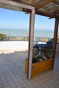 un patio con mesa y vistas al océano en La Scogliera B&B, en San Vito Chietino