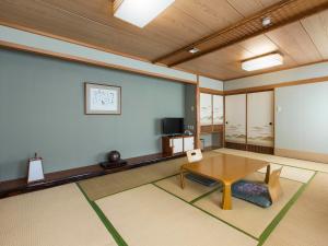 a living room with a table and a tv at Toya Gokirakutei in Lake Toya