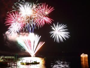 a group of fireworks exploding in the sky over the water at Toya Gokirakutei in Lake Toya +26 photos