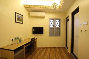 a room with a desk and a television on the wall at Shamrock Guest House II in Ipoh +34 photos
