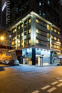 a building at night with cars parked in front of it at Pop Inn Mong Kok in Hong Kong