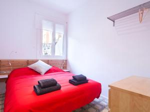 バルセロナにあるStay Barcelona Provençaのベッドルーム1室(赤いベッド1台、タオル2枚付)