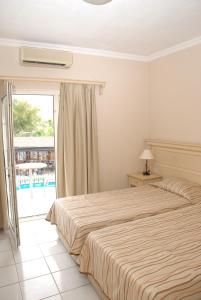 a bedroom with a large bed and a balcony at Tropicana Beach in Gümbet