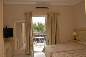 居姆貝特的住宿－熱帶海灘酒店，一间卧室设有一张床和一个滑动玻璃门