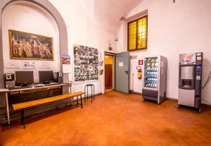 Großes Zimmer mit einem Schreibtisch und einem Kühlschrank. in der Unterkunft Hostel Santa Monaca in Florenz