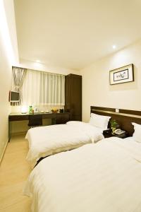 a hotel room with two beds and a desk at Pop Inn Mong Kok in Hong Kong