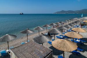 a group of umbrellas and chairs on a beach at Studio Nikos in Pythagoreio