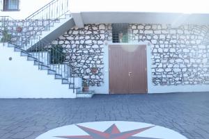 un edificio con puerta y pared de piedra en Aquamarine Apartment, en Vico Equense