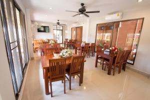 a dining room with wooden tables and chairs at Sri Siam Resort in Kanchanaburi City