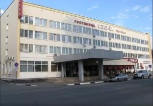 a large white building with cars parked in front of it at Ozery in Ozëry