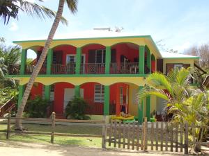 a red and yellow house with a red and green facade at Ababor Suites Guesthouse in Vieques