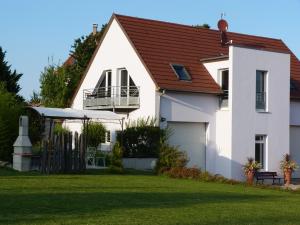 ein weißes Haus mit einem roten Dach und einem Hof in der Unterkunft Les gites de Georgia in Voegtlinshoffen