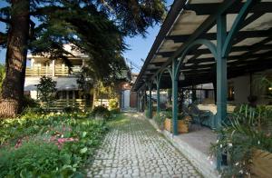 un jardín con una pasarela con flores y un edificio en Malpassuti Resort, en Carbonara Scrivia