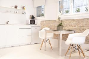 シッチェスにあるStudio Relax by Hello Homes Sitgesの白いキッチン(テーブル、白い椅子付)