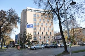 budynek z samochodami zaparkowanymi przed ulicą w obiekcie Hotel Logos w mieście Lublin