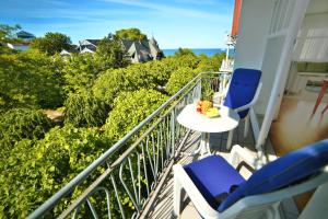 uma varanda com cadeiras azuis e uma mesa com vista em Haus Jahreszeiten em Binz