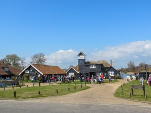 a group of people standing in front of a building at Boat Lake in Thorpeness