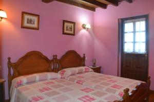 a bedroom with pink walls and a bed at La Corrada in Priede