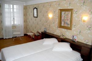 1 Schlafzimmer mit 2 Betten und einem Wandspiegel in der Unterkunft Auberge des Ruines de Merle in Saint-Cirgues-la-Loutre