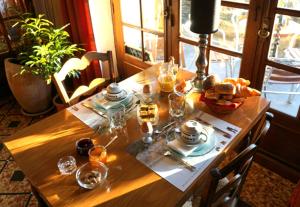 einem Holztisch mit einem Teller Essen drauf in der Unterkunft Auberge des Ruines de Merle in Saint-Cirgues-la-Loutre
