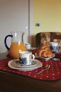 a table with a cup of tea and a plate of croissants at B&B Doria Valle Maira in Roccabruna