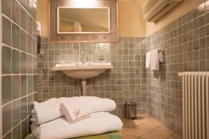 a bathroom with a sink and a pile of towels at Tenuta La Cascinetta in Buriasco +21 photos