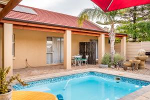 a house with a swimming pool in front of a house at Guesthouse De Tijger Lodge in Parow
